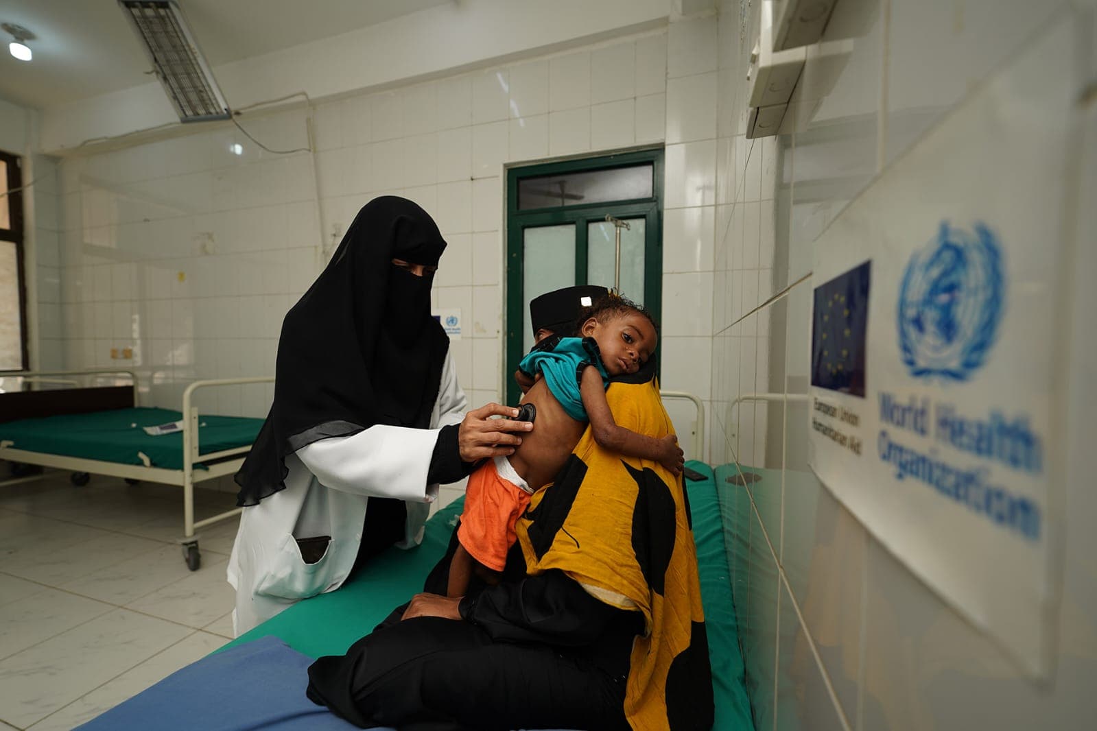A health worker examines a child at a WHO supported health facility. Photo credit: WHO/Yemen